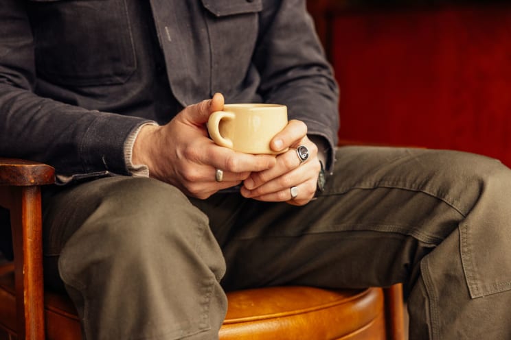A Person Holding A Cup In A Room