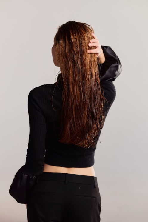 A Woman With Long Brown Hair Models A Black Sweater With Puffed Sleeves