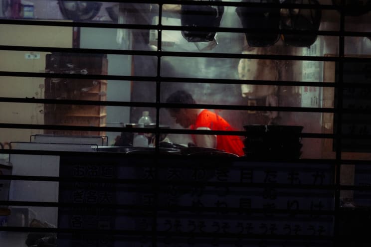 A Man Inside A Restaurant Kitchen Wearing Orange Shirt