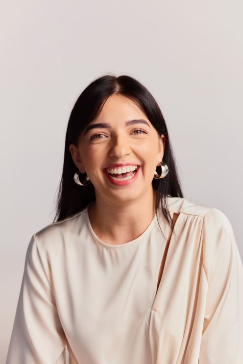 A Woman Is Smiling Really Big As She Poses