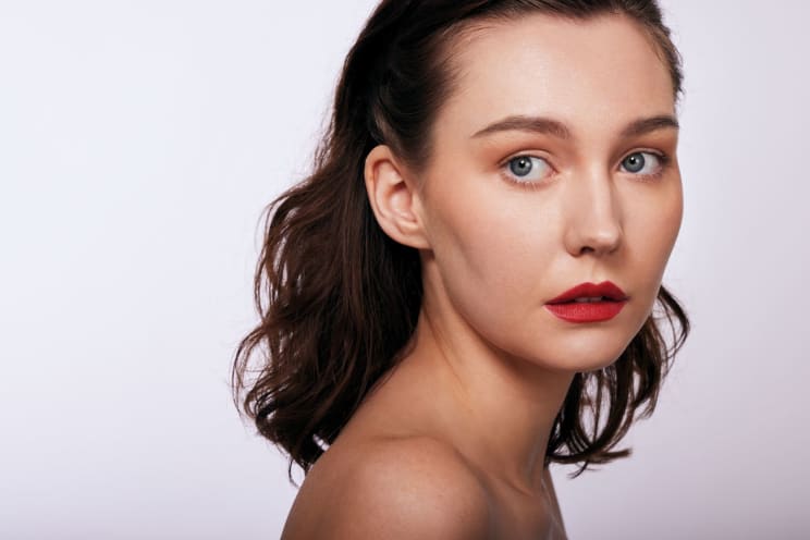 Woman, With Loose Hair And Soft Makeup With Red Lips And Neutral Background