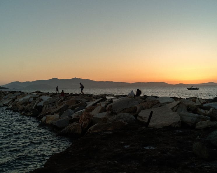 People Walking On Rocks Near The Lakeshore
