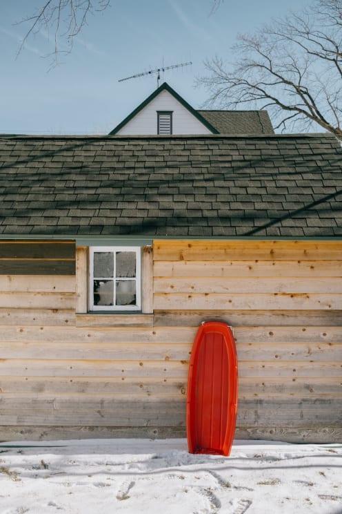 Exterior Of Wooden House With Red Plastic Board
