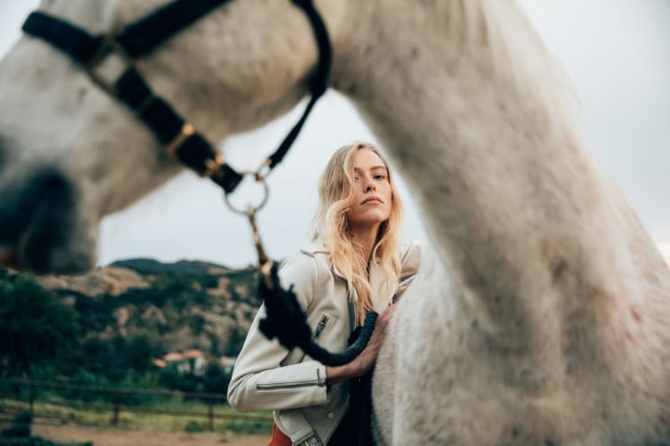 A Woman With Blonde Hair Takes A Selfie With A Horse In Nature