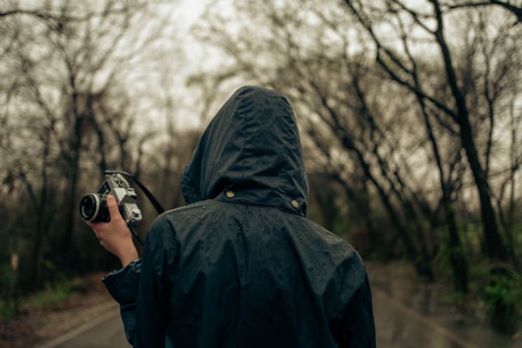 A Person Walking Outdoors With A Camera