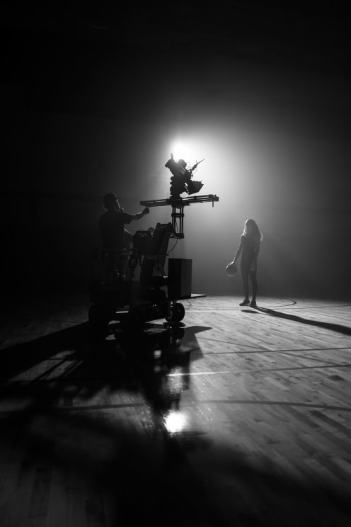 A Man On A Camera Vehicle Films A Woman On A Basketball Court