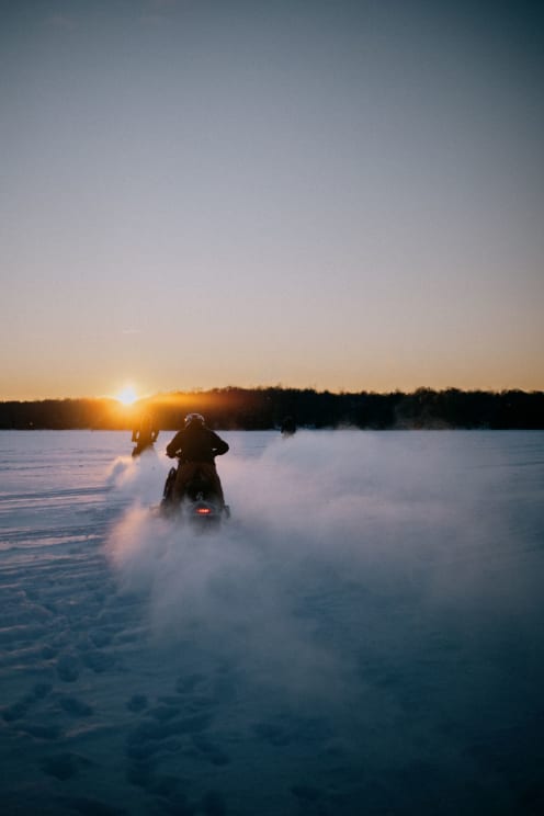 People Riding In Vehicles On An Icy Landscape