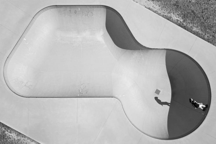 A Skateboarder Skates Inside A Dry Pool