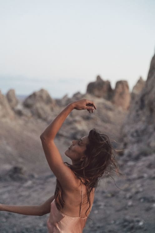 A Woman Poses Near Rocks On A Rocky Surface