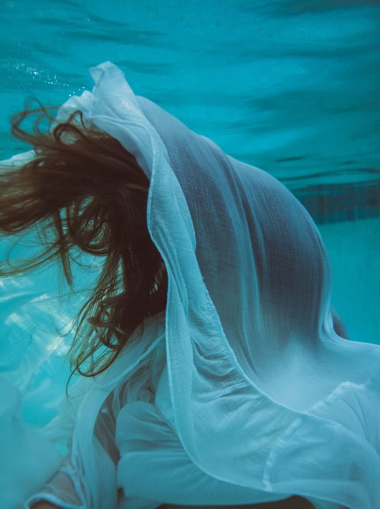 Redheaded Woman Underwater With Hair And Floating Clothes Covering Her Face