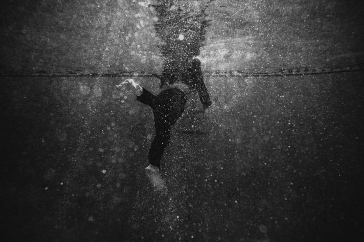 A Fullyclothed Person Swimming In A Pool