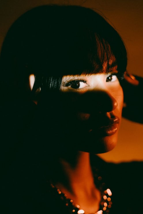 A Brightly Illuminated Young Woman In Darkness