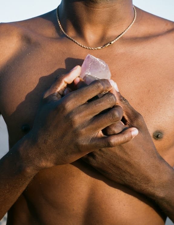 A Person With Black Hair Meditating On The Beach