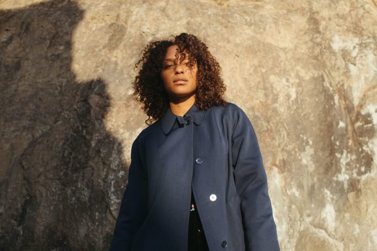 A Woman Standing Outdoors Wearing A Jacket