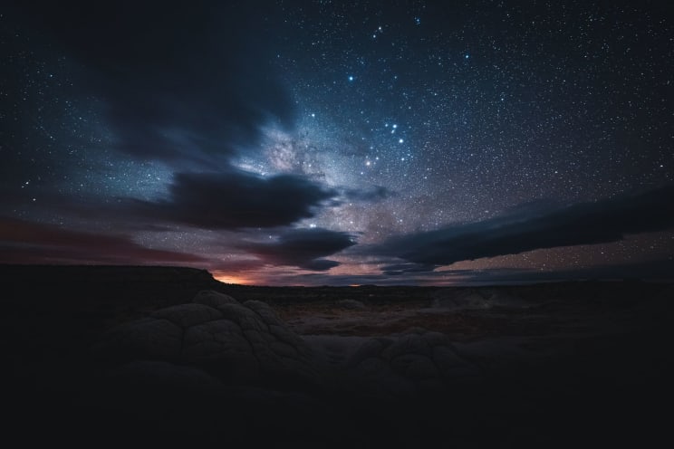 A Dark Landscape With A Starry Night Sky Above