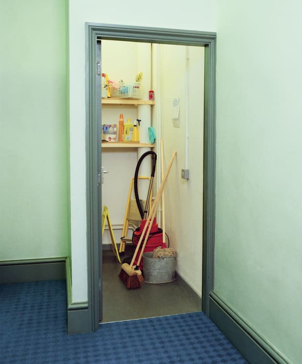 A Room With Cleaning Supplies Including A Broom Mop Bucket And Step Ladder