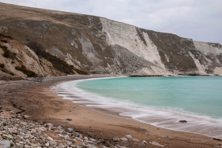 Blue Ocean Water Laps A Rocky Beach