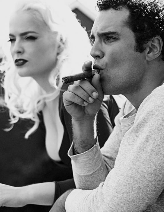 A Man And A Woman Sitting Together With The Man Smoking A Cigar