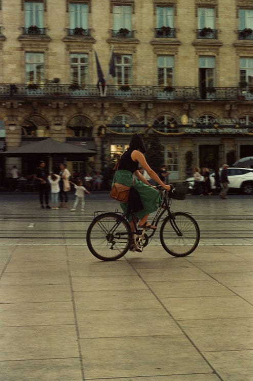 A Woman Cycling In A Downtown Area With Buildings And Cars