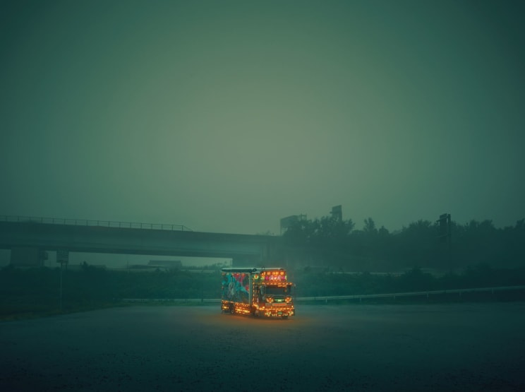A Shipping Semi Truck Drives On A Road During A Foggy Day
