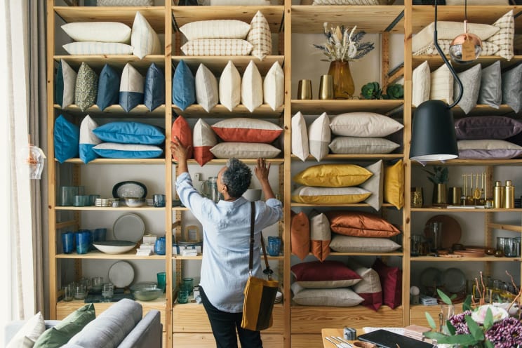 A Woman Browsing Pillows At A Home Furnishings Store