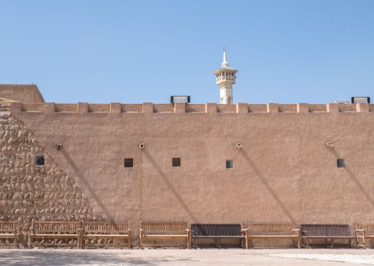Fortress Surrounded By A Giant Wall With Brown Benches Next To It