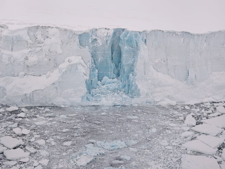 A Frozen Mountain Landscape With A Clear Sky And A Body Of Water
