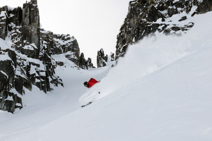 A Snowy Mountain Slope With Trees And Sports Equipment