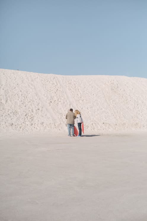 A Man And A Woman Explore A Snowy Hill
