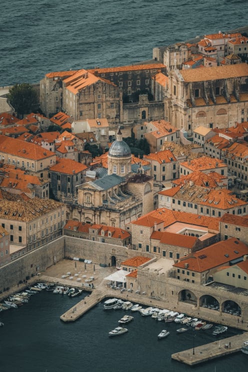 An Aerial Cityscape Of A Coastal City On The Ocean With Boats