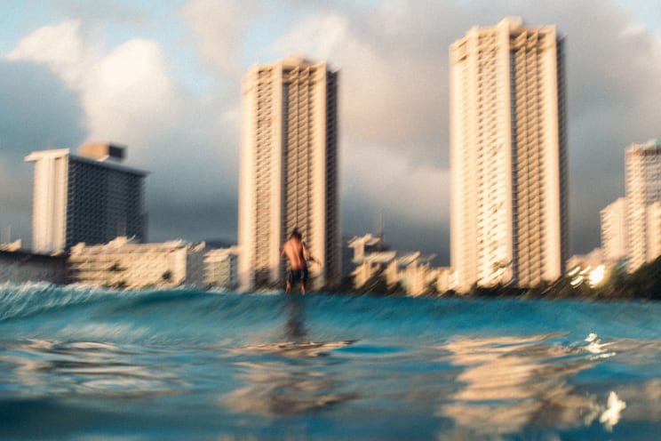 A Man Surfing A Wave With A Blurry Background