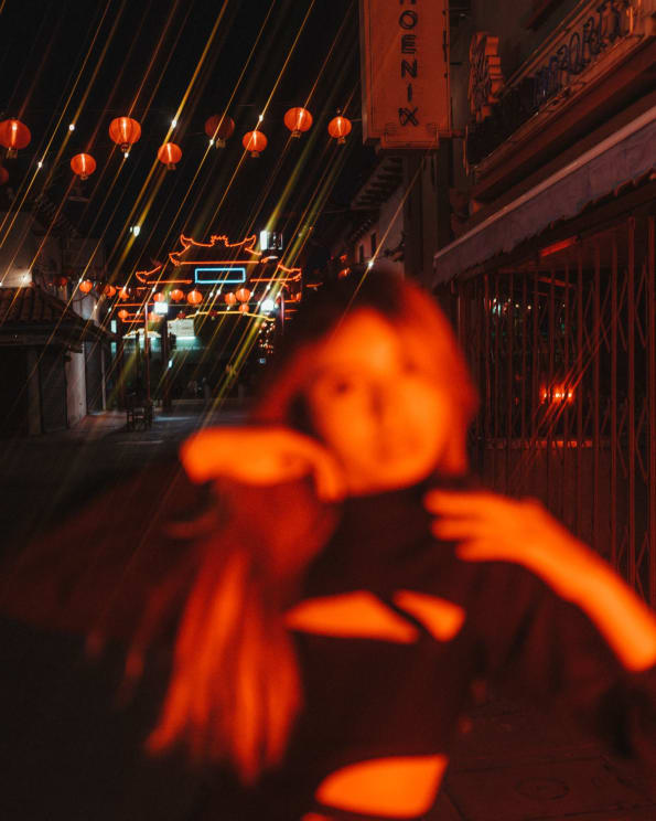 Blurry Woman Poses On Street Lit By Chinese Lanterns