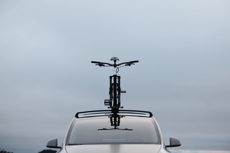 Bike Is Mounted On The Roof Of A Silver Car With A Bike Mount