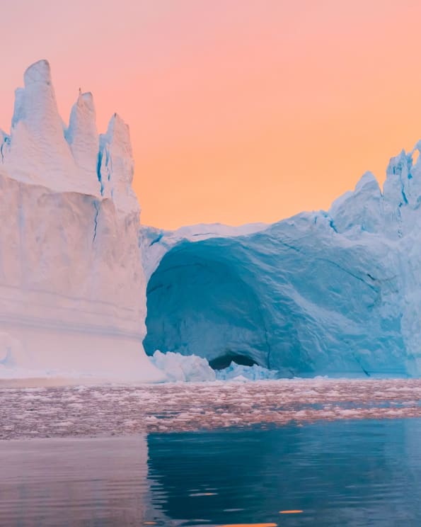 An Iceberg Reflects Onto The Water Below