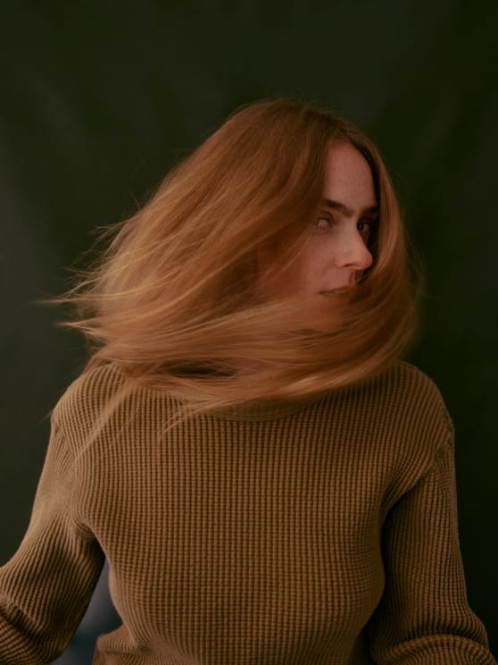 A Young Women Flipping Her Hair To The Side As She Looks From The Side