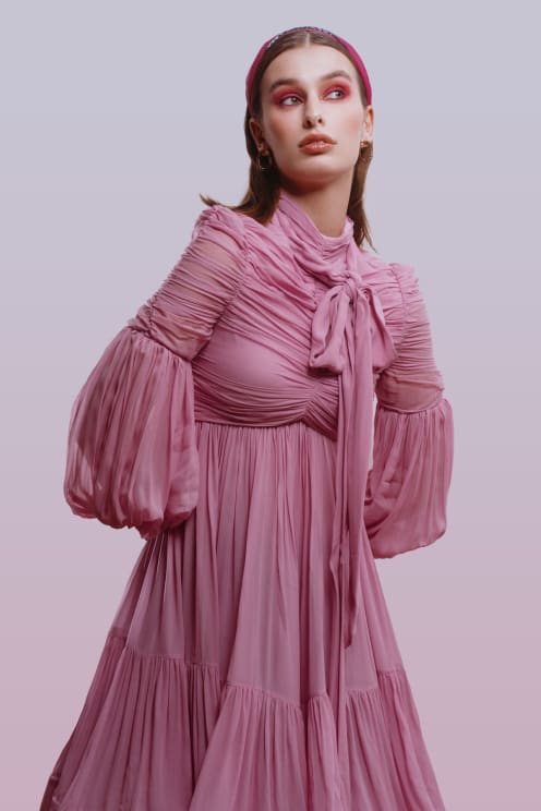 A Woman Models A Pink Pleated And Ruched Dress