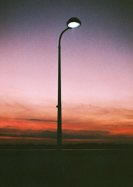 Single Streetlamp Shines At Sunset