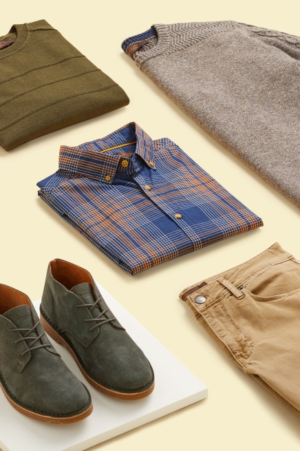 Stitch Fix X County Capsules popular Devon men's outfit featuring a plaid yellow and blue shirt, camel chinos, a light brown jumper, a green jumper and dark green suede shoes.