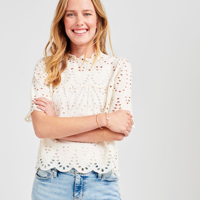 Stitch Fix model wearing a petite cream lace top, petite blue jeans and gold bracelets.