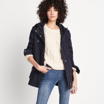 Model wearing a Stitch Fix outfit featuring a petite black jacket, a petite white top, petite skinny blue denim jeans and flat shoes.