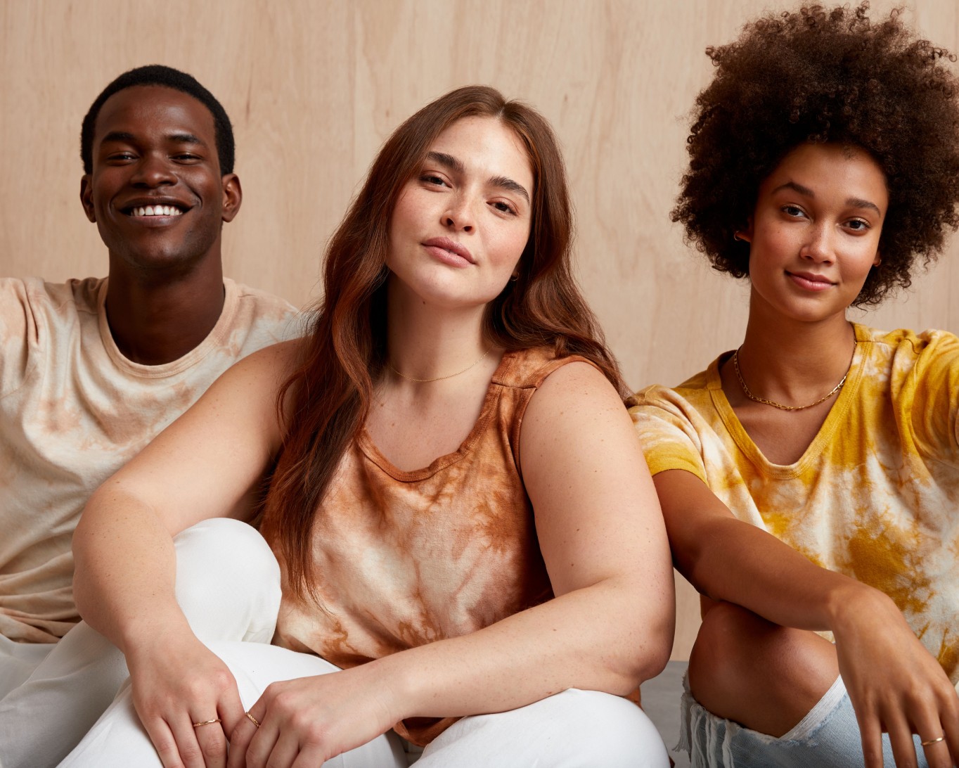 Models sitting wearing Stitch Fix Mohnton Made Earth Day cloud wash tees in blush avocado, cutch brown and fustic yellow.