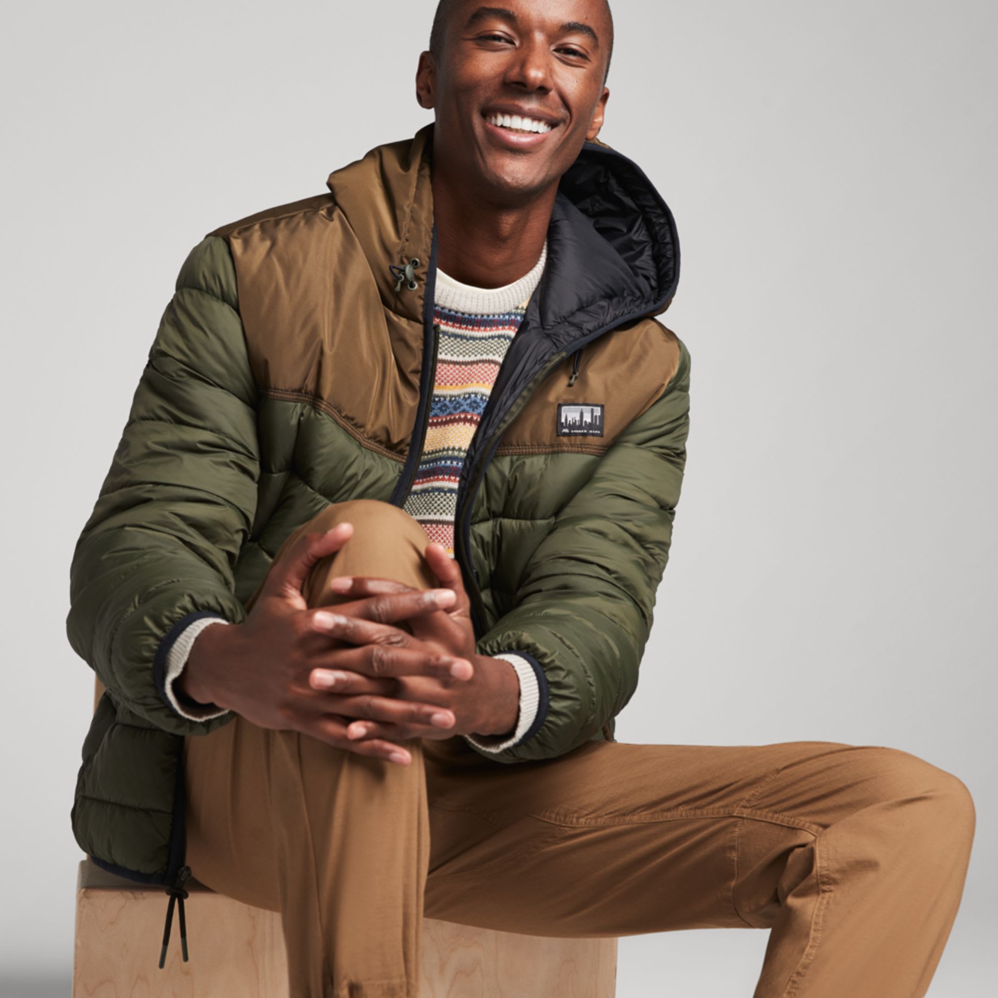 Model wearing Stitch Fix men’s clothing including crew neck sweater and colorblock jacket.