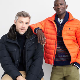 Black and orange men’s athleisure puffer jackets over dark tops.