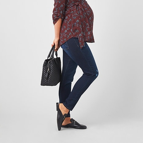 Maroon printed shirt with dark wash jeans, black handbag and mule shoes.