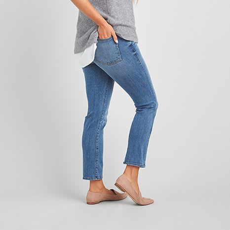 Grey and white top with medium wash ankle length jeans and nude flat shoes.