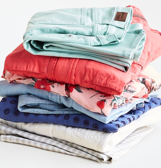 Stack of Stitch Fix spring clothing for women including color jeans, floral top and utility jacket