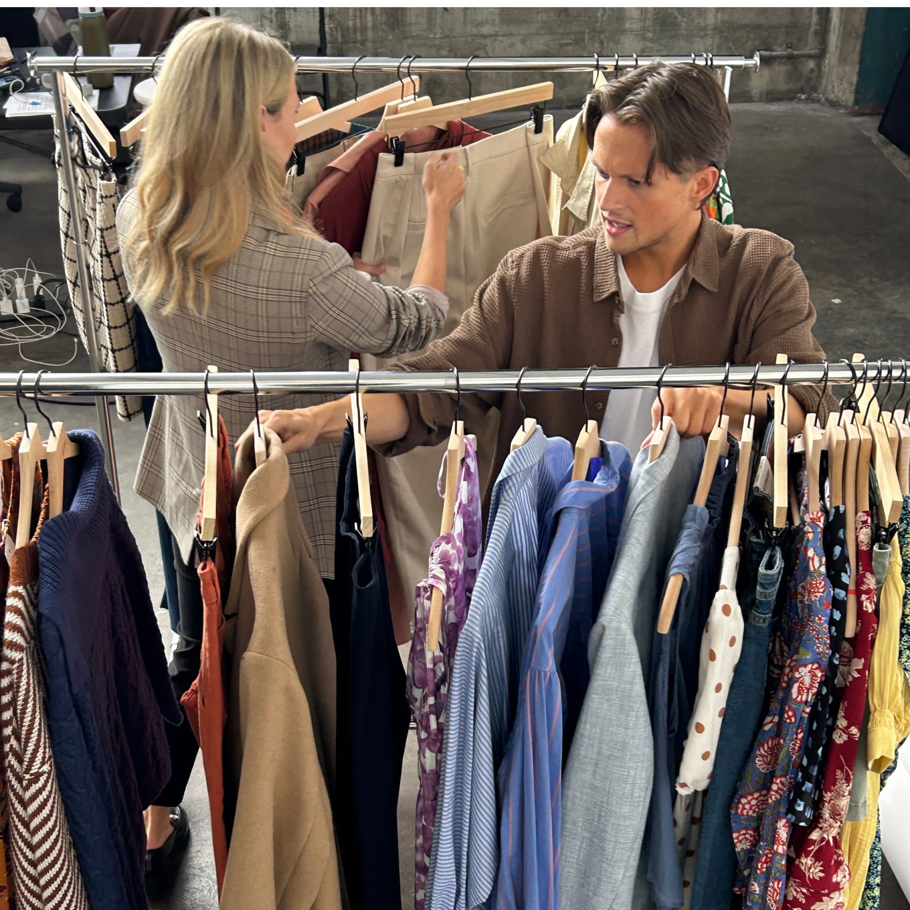 Two Stitch Fix Stylists in between racks of Stitch Fix men’s clothing