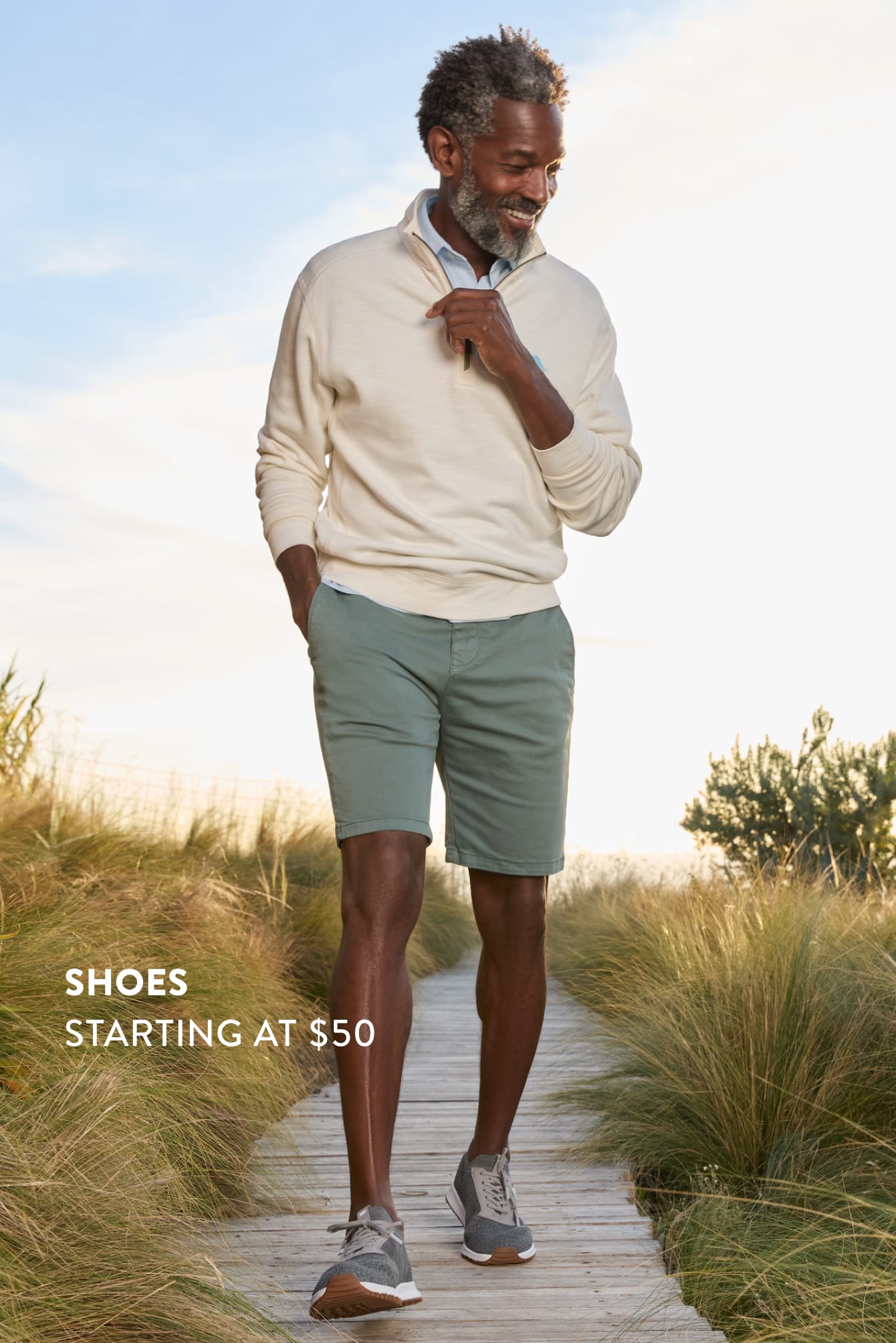 Shoes starting at $50, man wearing Stitch Fix men’s cream quarter-zip sweater, green shorts and sneakers