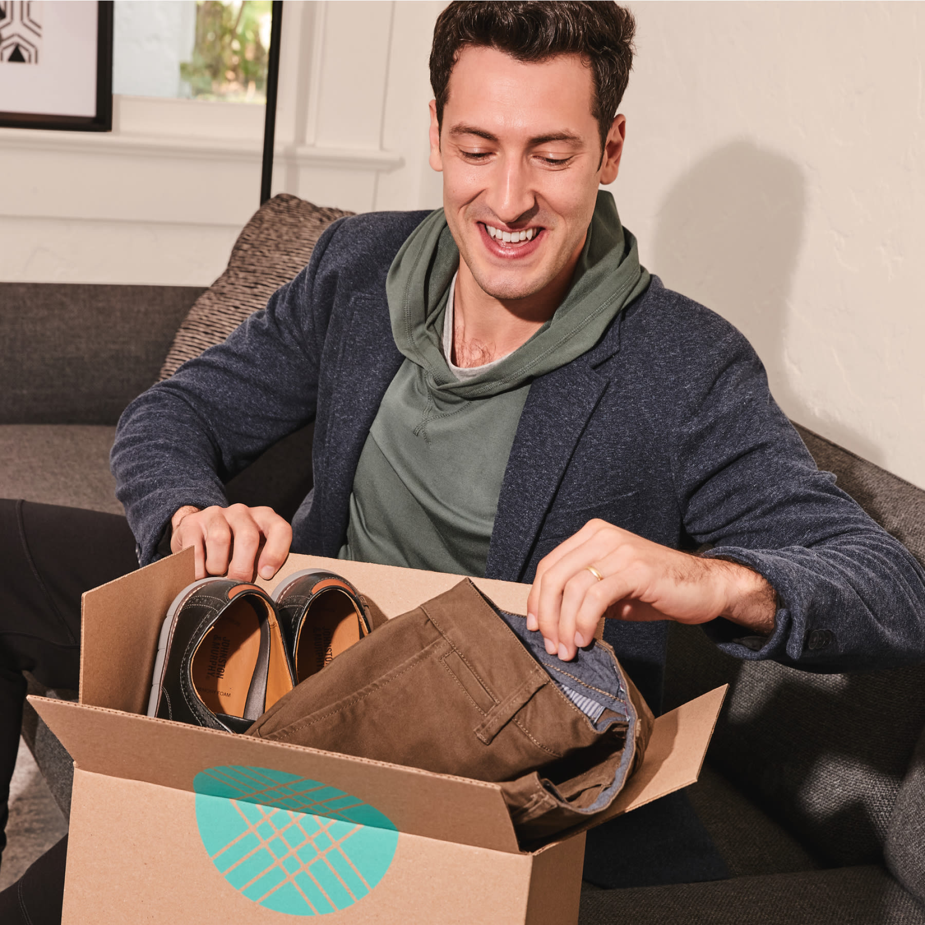 Man opening Stitch Fix box with Stitch Fix men’s clothing