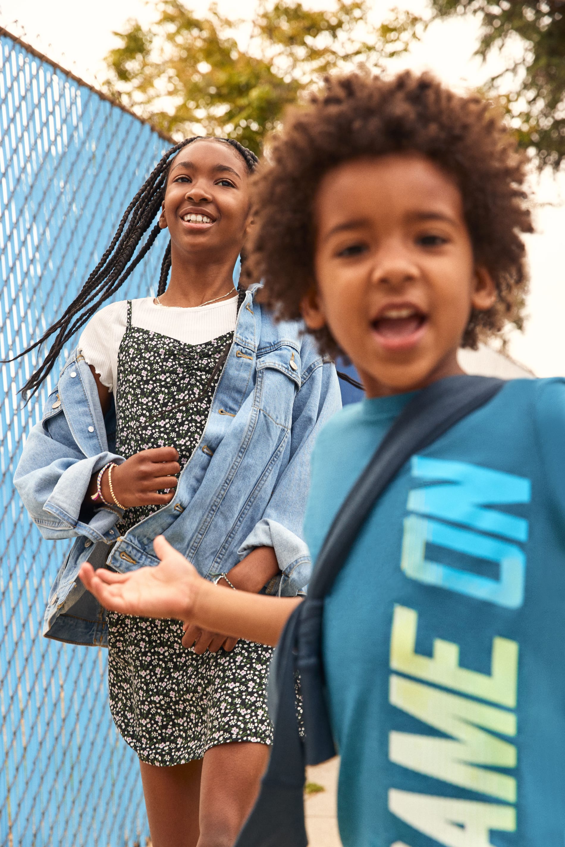 Models wearing Stitch Fix kids’ clothing including patterned girl’s dress, girl’s jean jacket, boy’s shirt and hoodie.